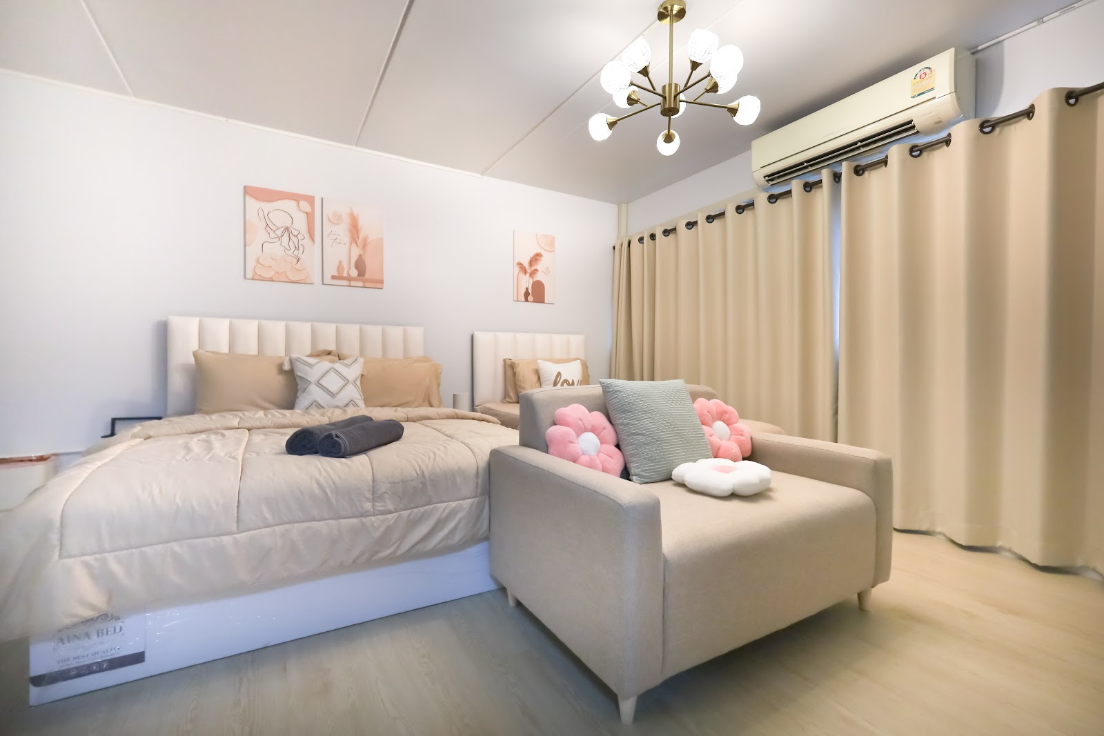 Our C2 studio — cream beds, gold chandelier and pink flower cushions