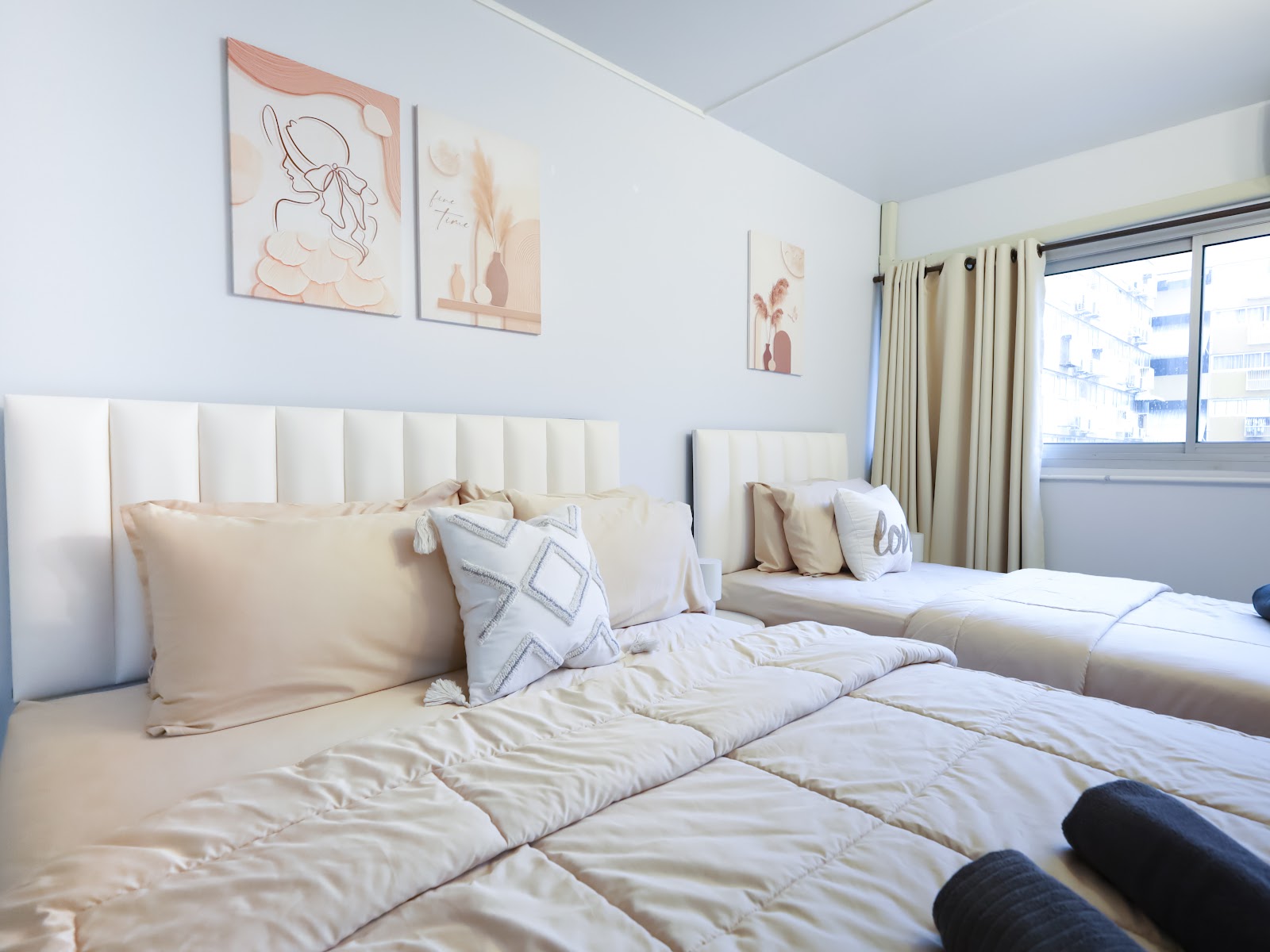 Twin cream beds with blush wall art